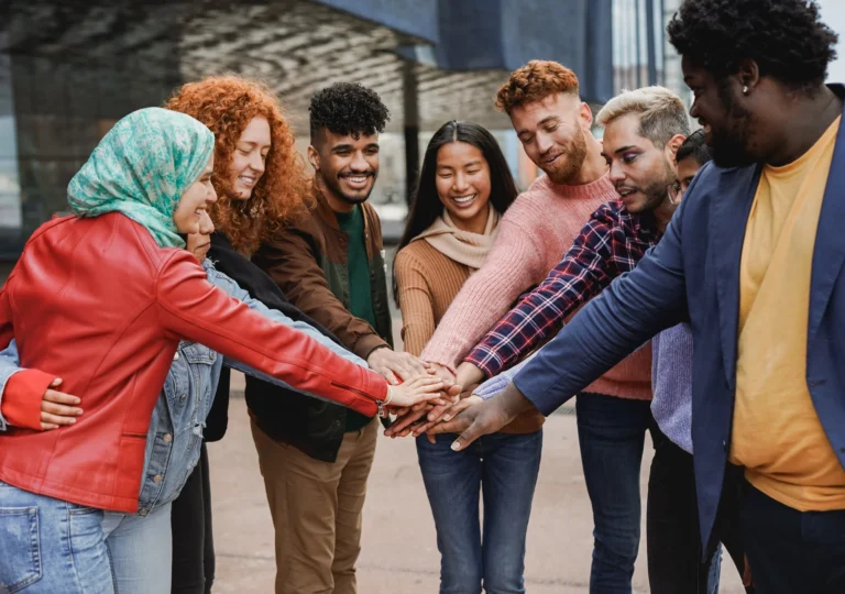 Young university students stacking hands together outdoor - Multiracial people and community concept
